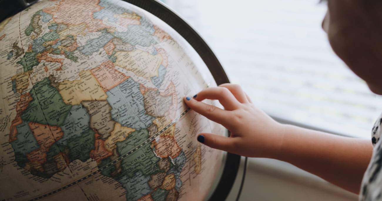 A child touching a globe.
