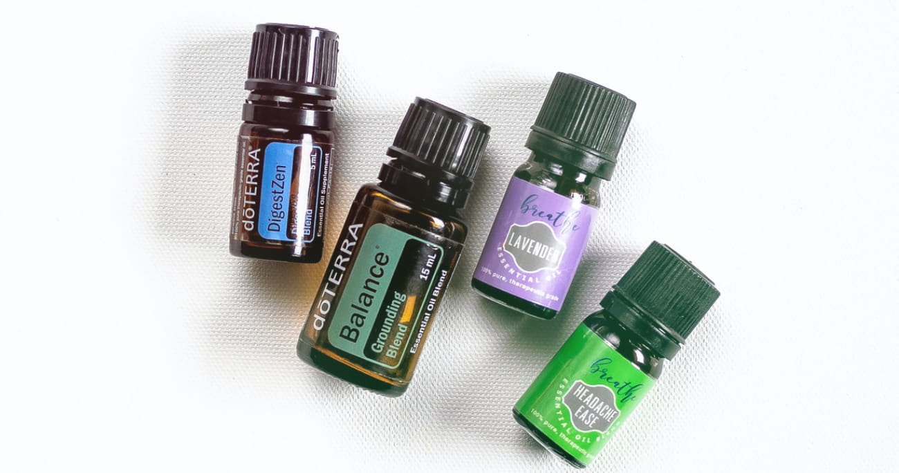 four small bottles of essential oils on a white background