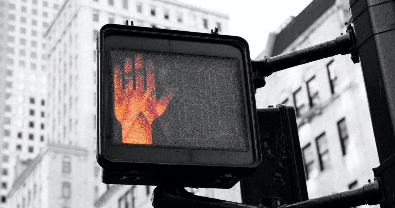 a crosswalk sign with the stop hand illuminated