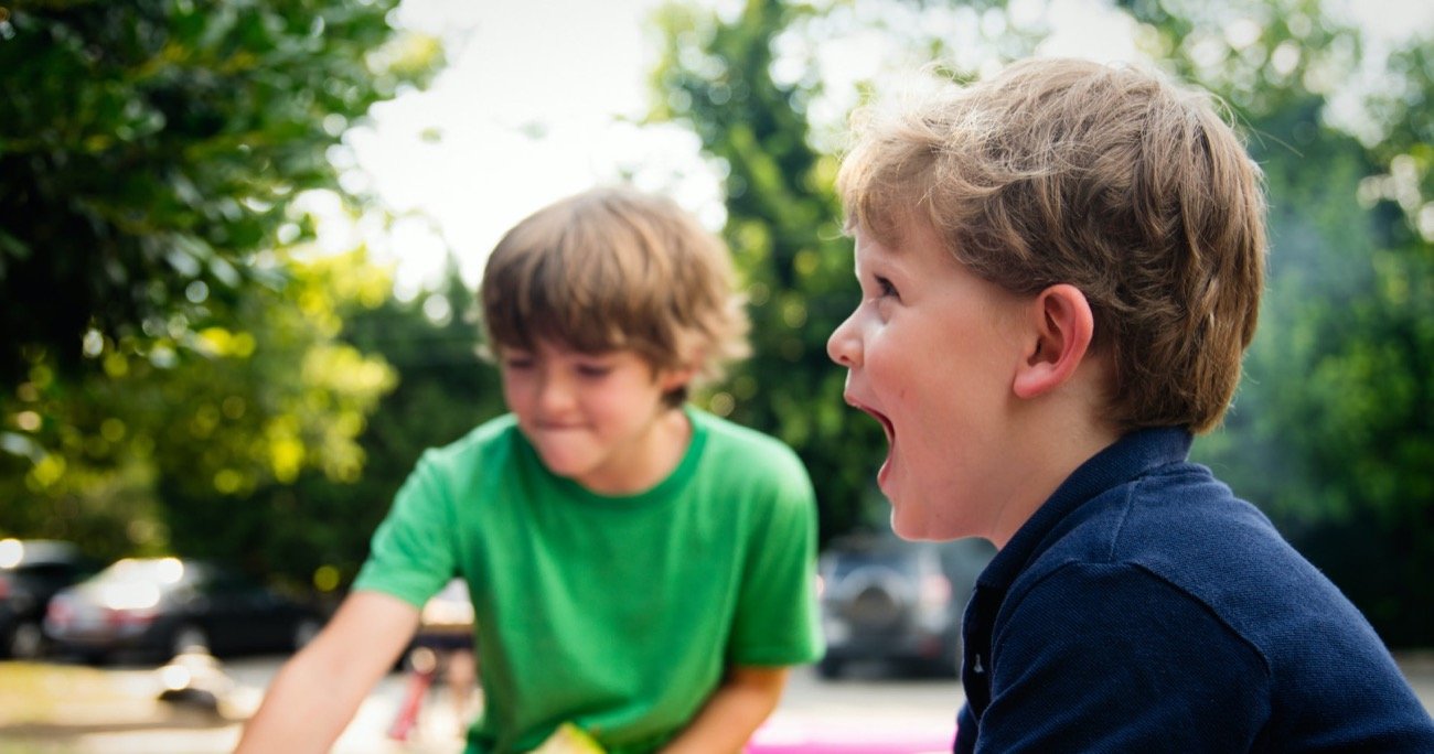Two young boys playing outside and laughing