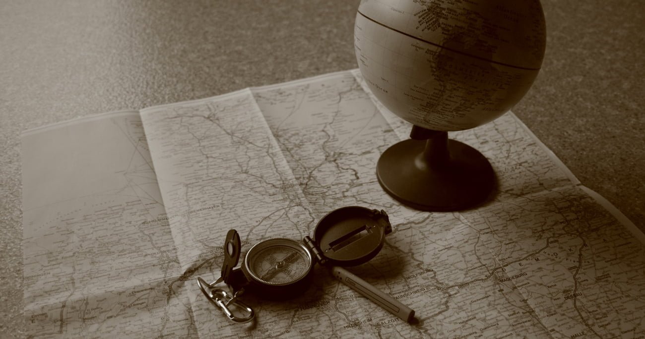 map on a table with a globe and compass on top