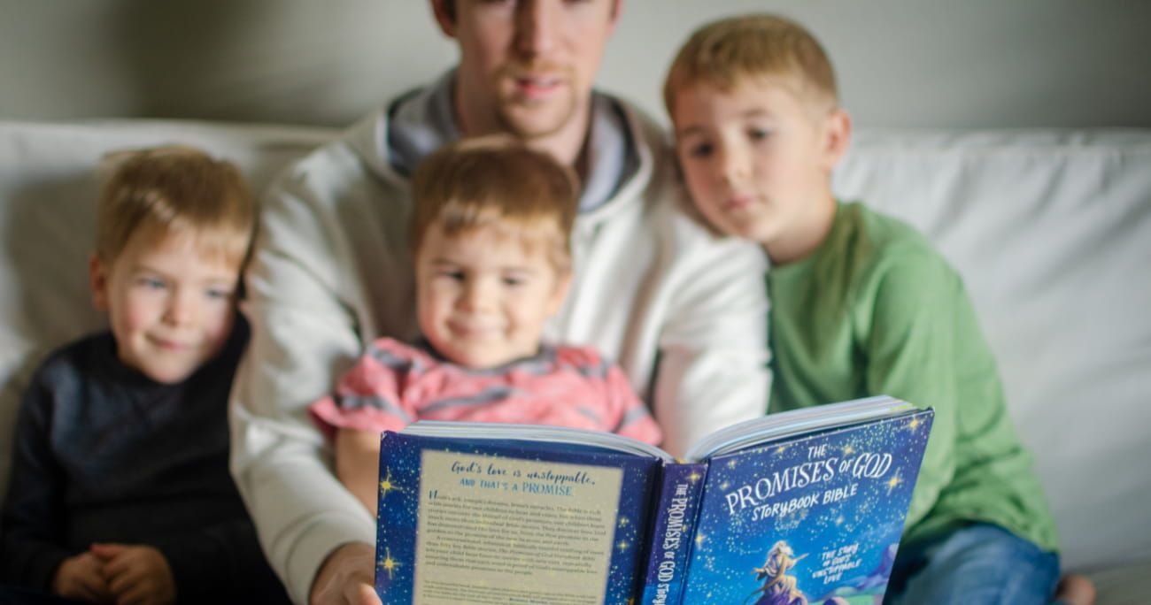 Dad reading the Promises of God Bible Storybook to his kids