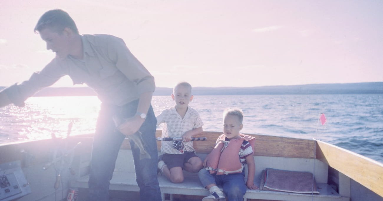 dad on a boat with his two young boys
