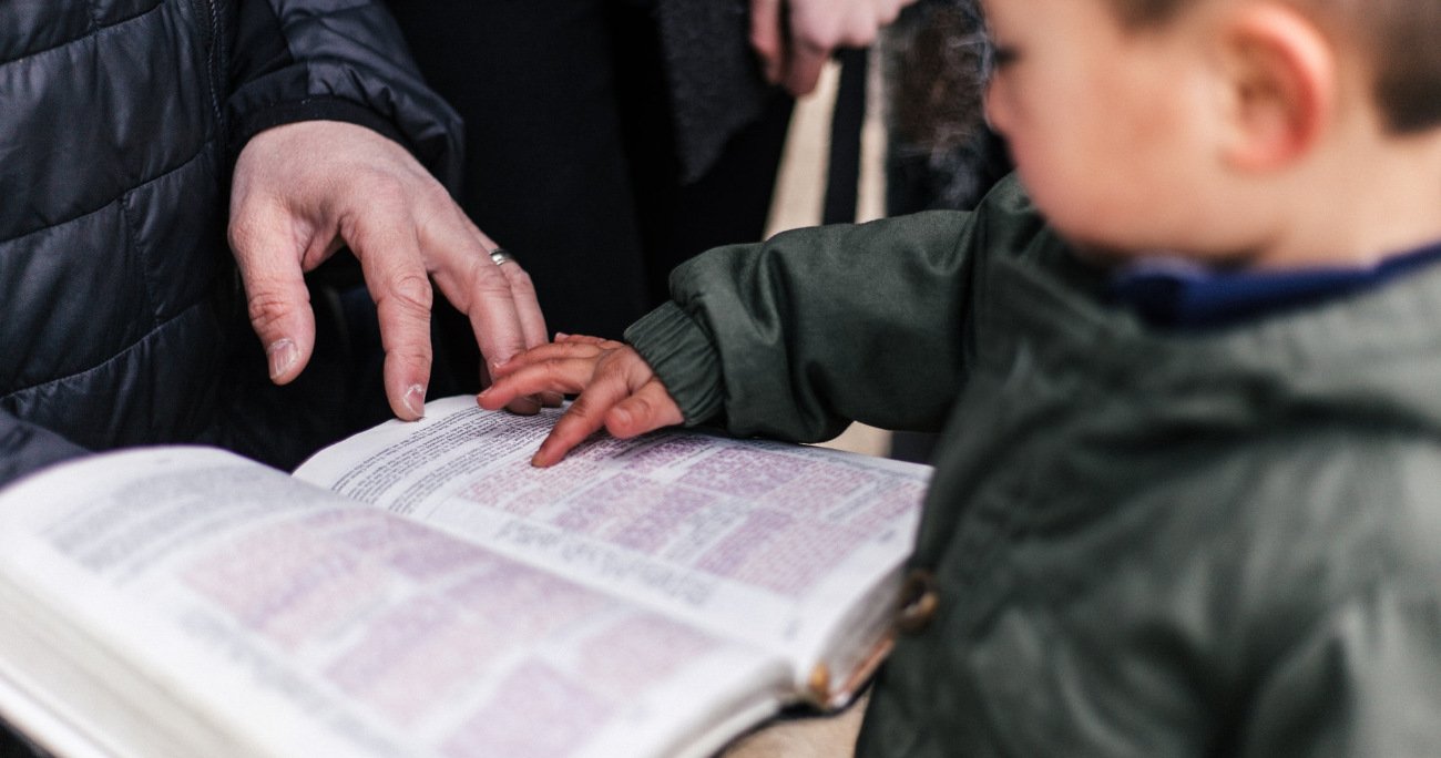 dad and son looking at an open Bible