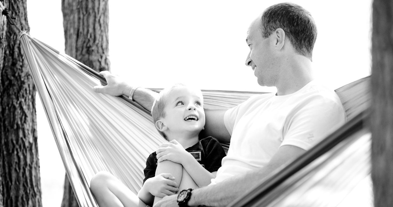 Dad and son talking and sitting in a hammock
