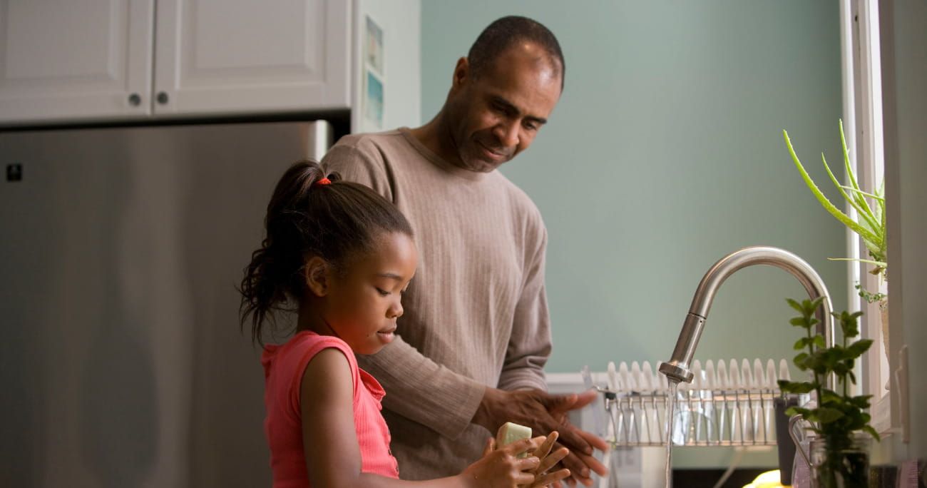 father and daughter washing dishes