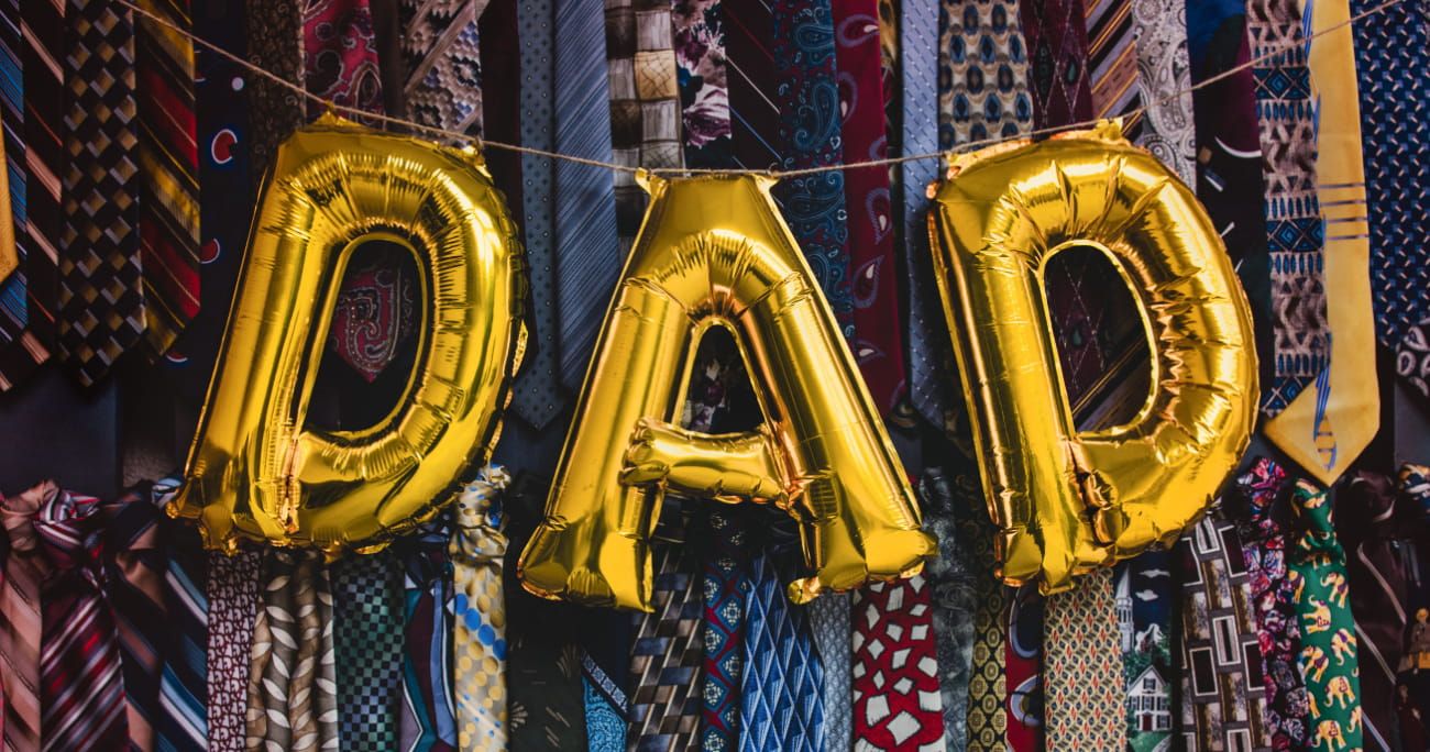 balloon of the word dad with neck ties in the background
